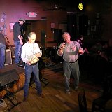 Joel Edison (luthier and J4D Trustee, left) and Tom Krebs prepare to give away the J.Edison Custom Guitar